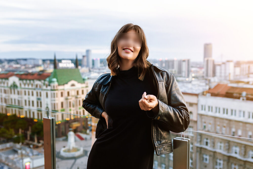 Leijla Foss smiling on a balcony, gesturing "come hither"